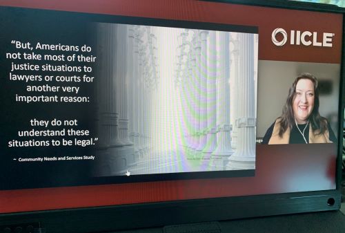 Anne-Marie virtually delivering Eliminating Barriers to Legal Access: Obstacles and Opportunities for Your Practice as part of the Illinois Institute for Continuing Legal Education's 17th Annual Elder Law Short Course in 2021. The slide on the screen reads: "but, Americans do not take most of their justice situations to lawyers or courts for another very important reason: they do not understand these situations to be legal." A quote from the Community Needs and Services Study.